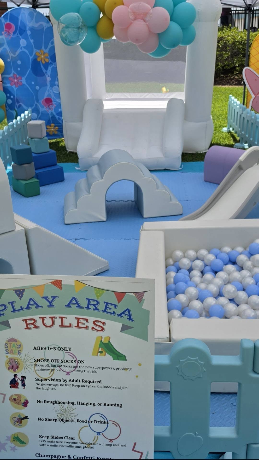 Outdoor kids soft play area with ball pit, foam climbers and a white bounce house