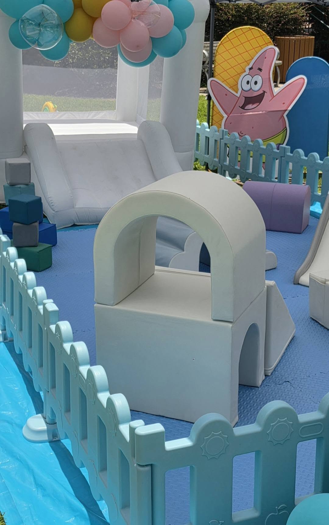Soft play foam climber and slide inside a pastel fenced play area