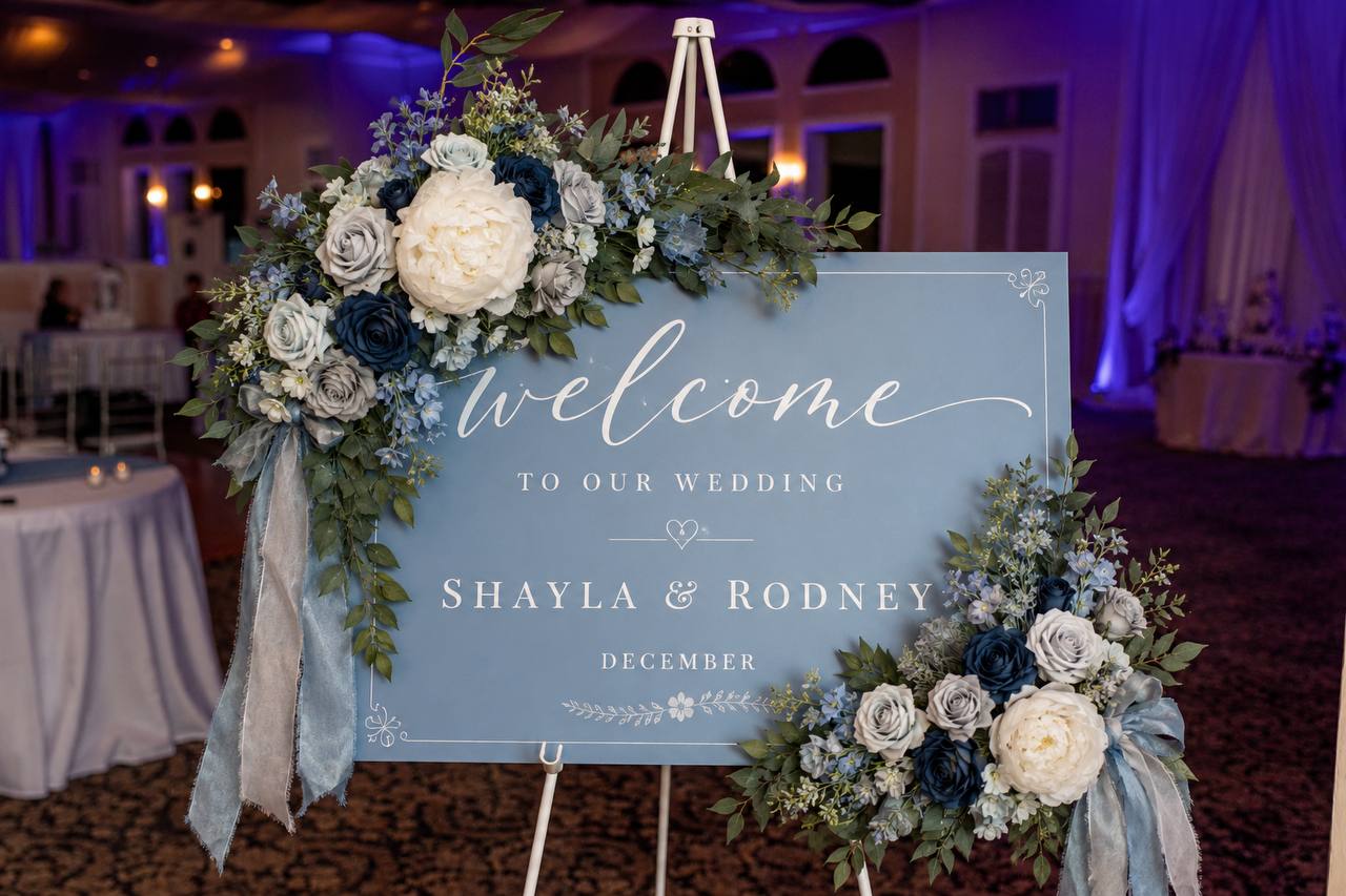 Dusty blue welcome sign for Shayla and Rodney framed with blue and ivory florals